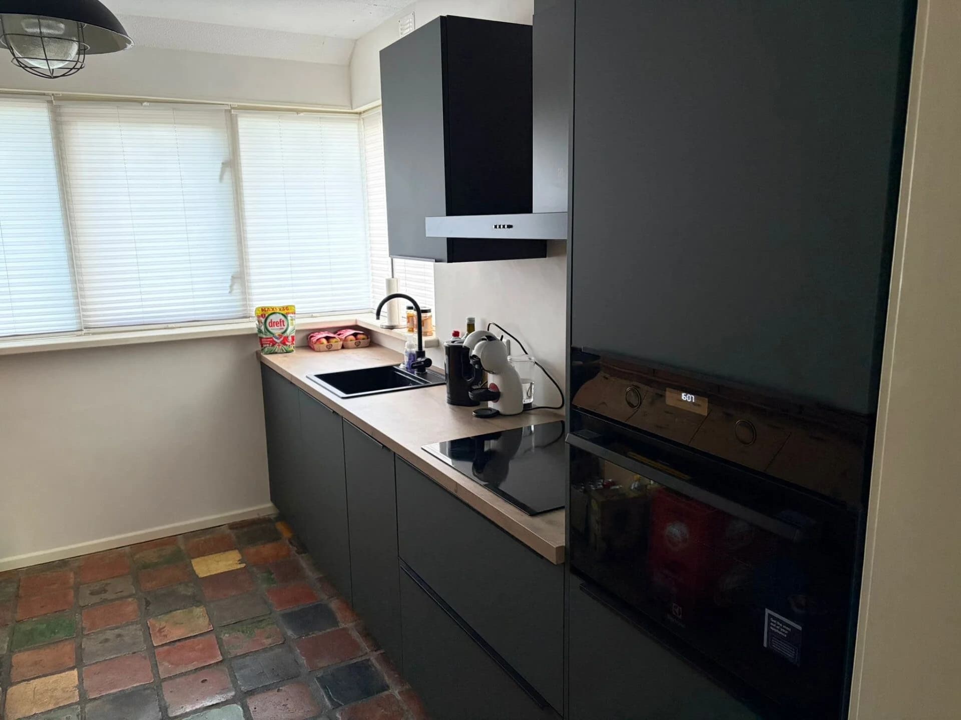 Antraciet greeploze keuken met houten werkblad