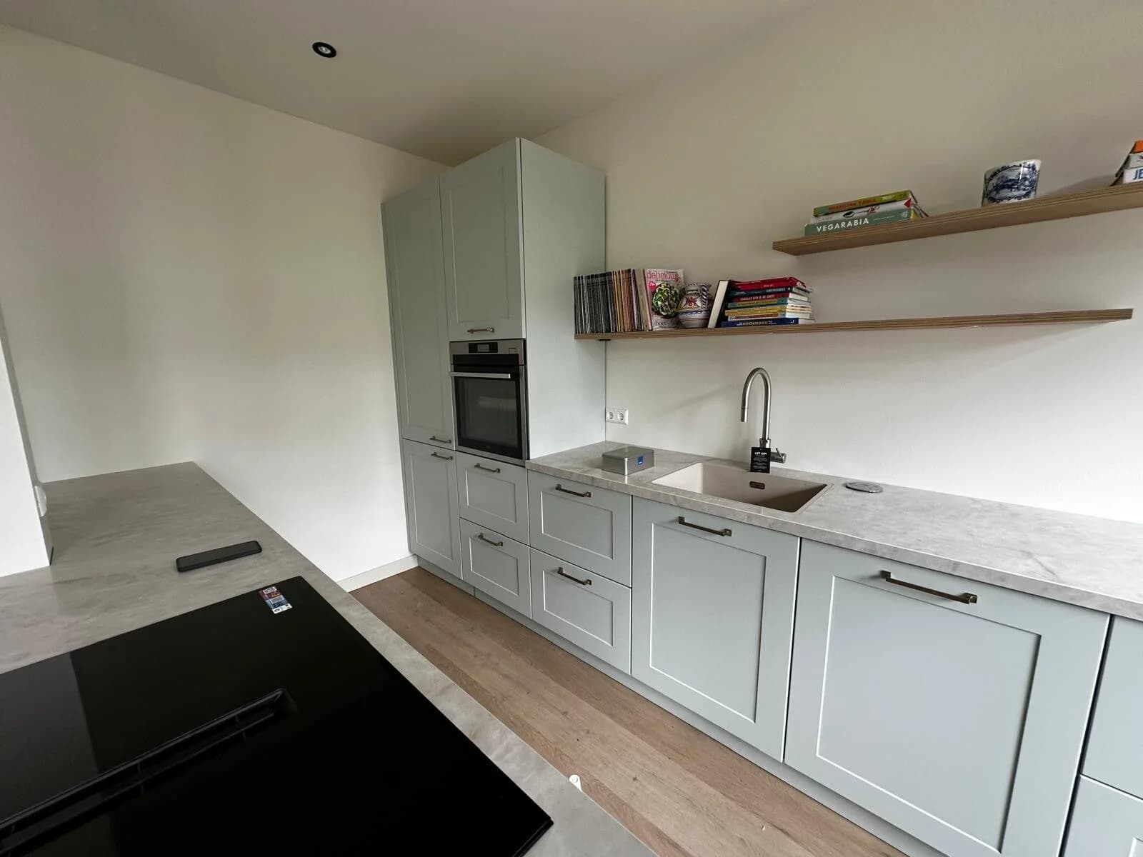Grijsgroene shaker keuken met eiland en marmer werkblad