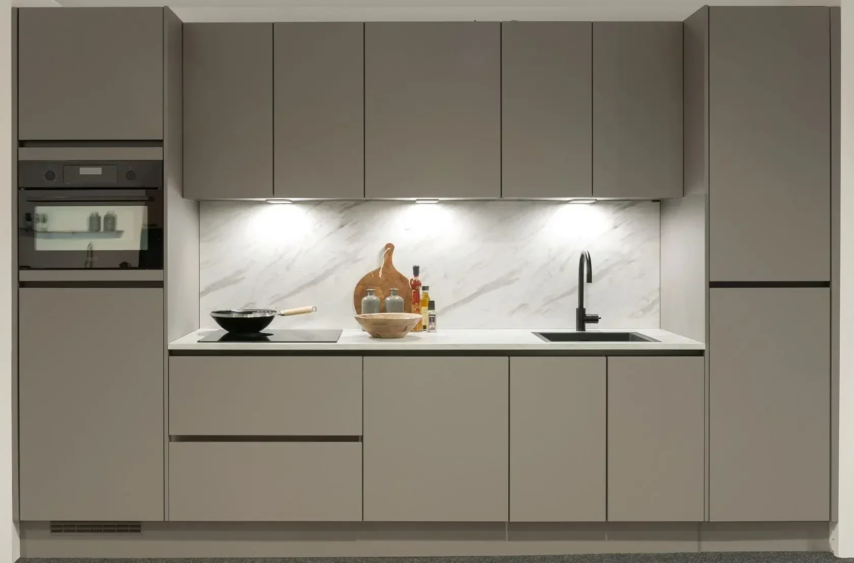 Taupe greeplose keuken met marmeren achterwand