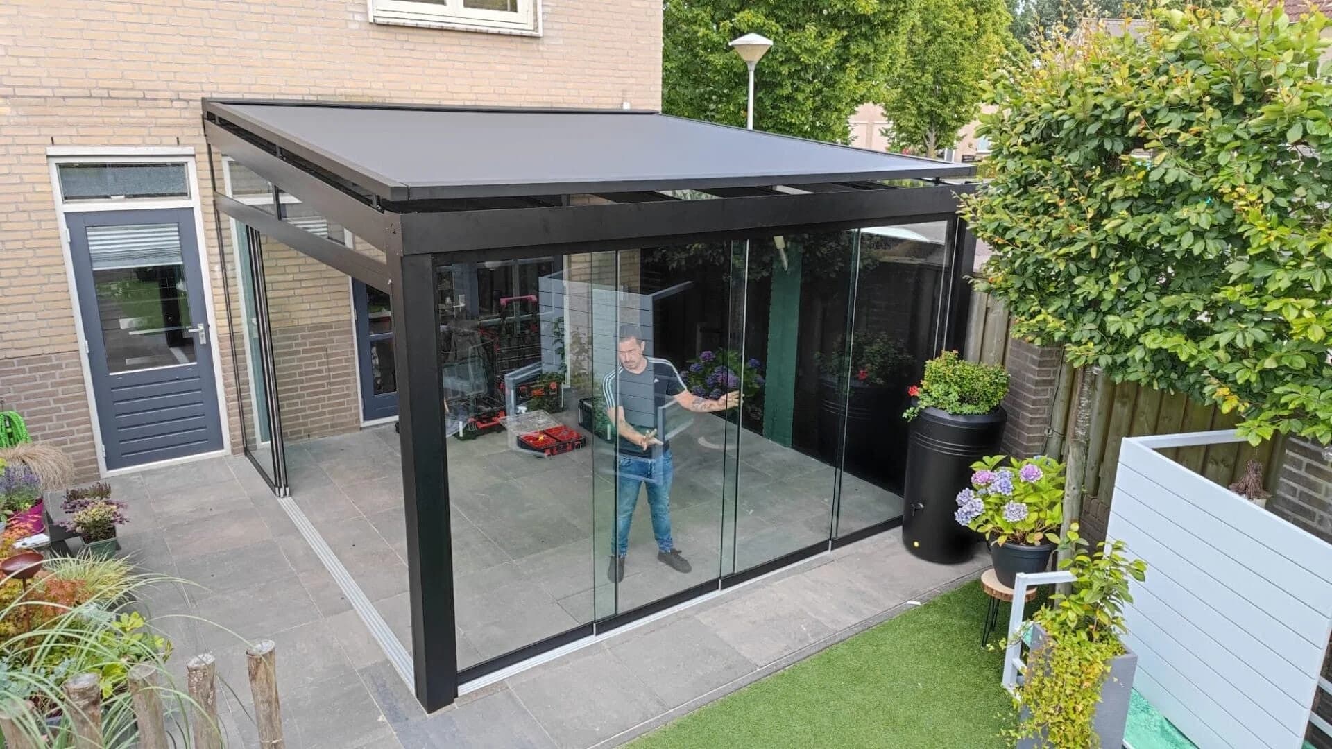 Glazen veranda in zwart aluminium in tuin
