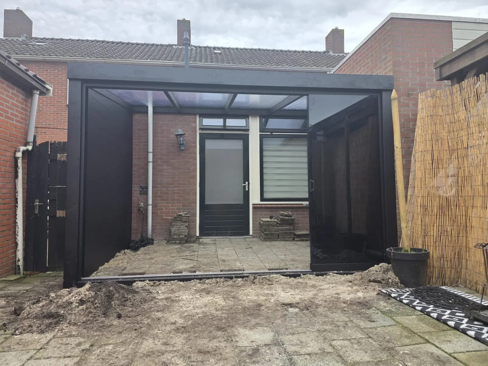 Overkapping in Alkmaar: antraciet met glazen schuifwanden en dichte zijwand