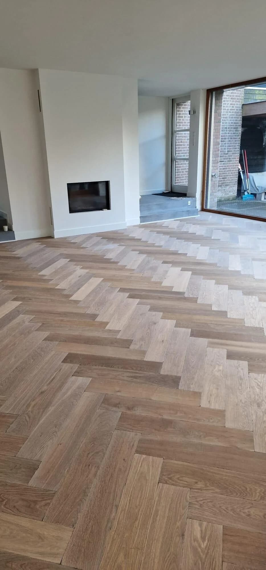 Eiken visgraat vloer in woonkamer met haard