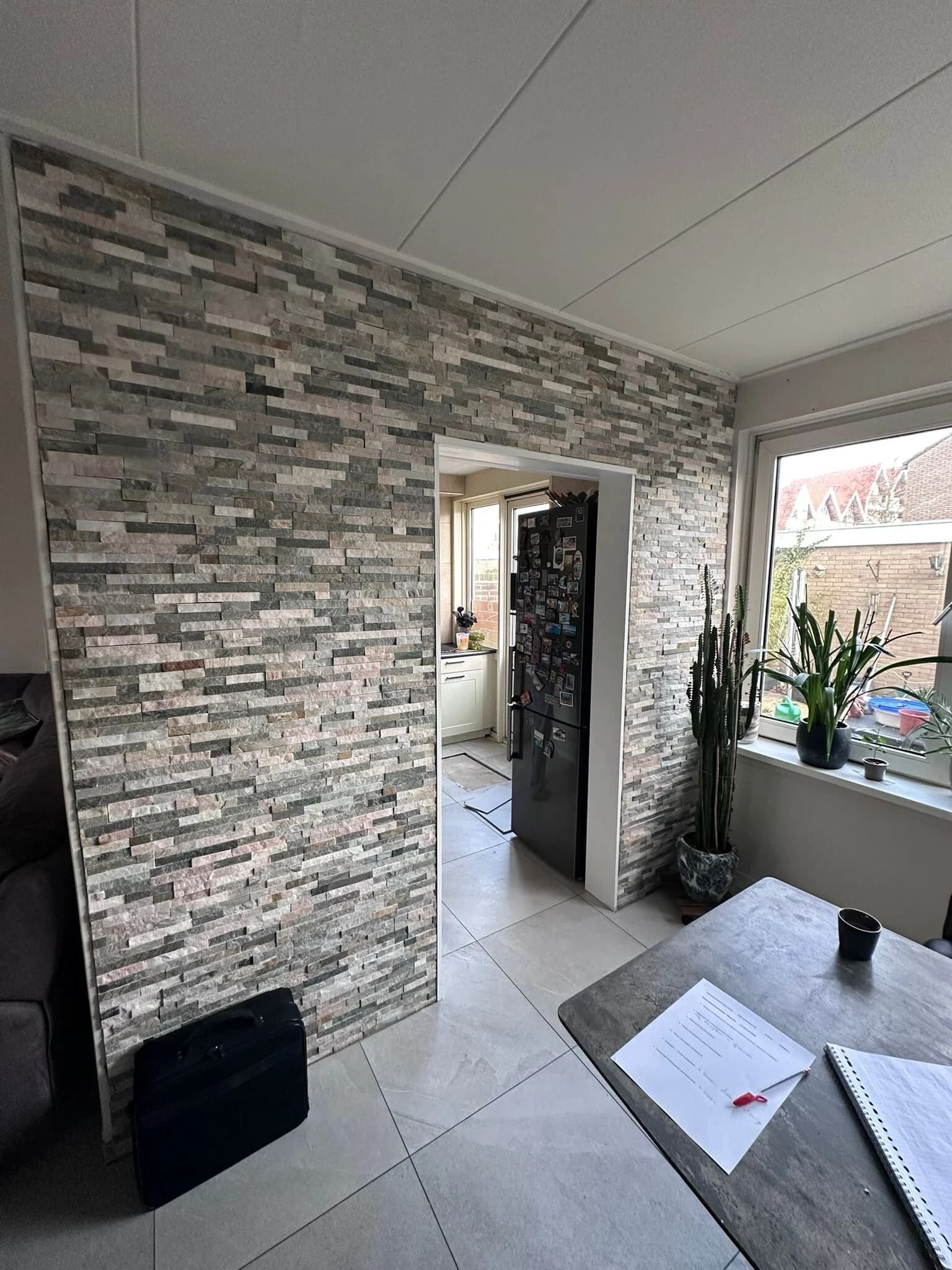 Woonkamer met steenstrips accentmuur na renovatie