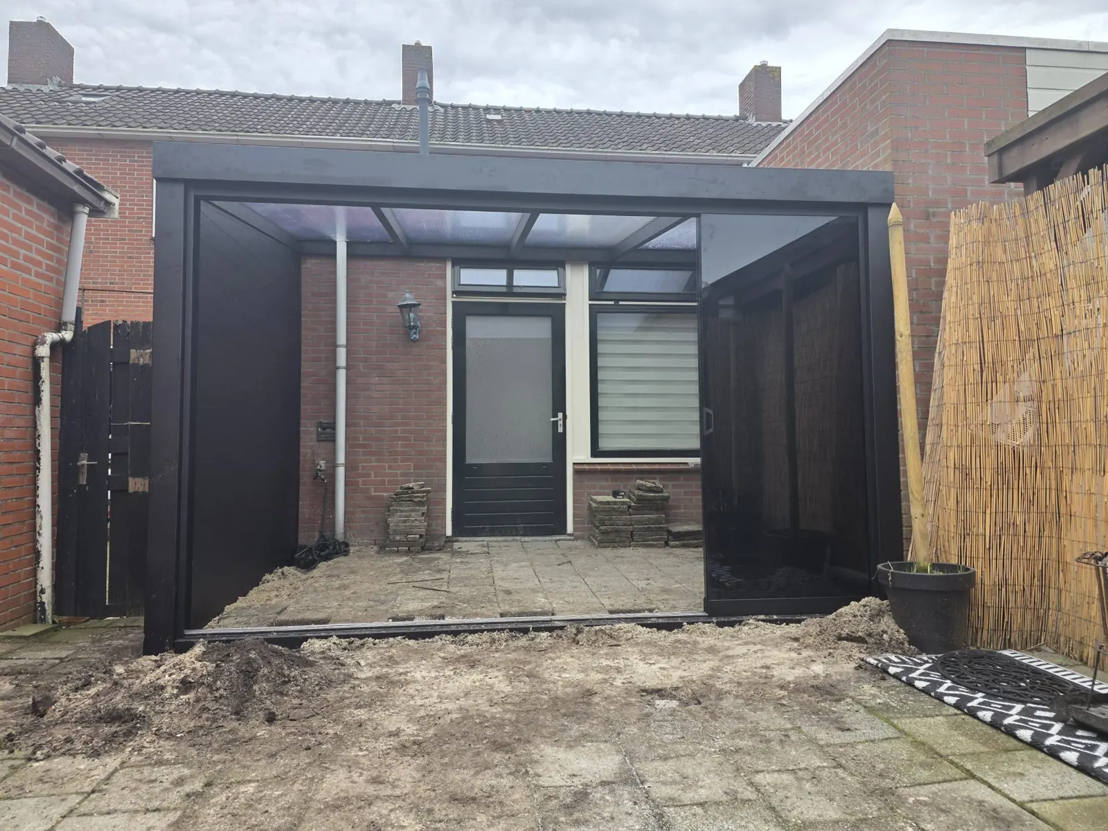 Overkapping met doorzichtig dak, dichte zijwand en glazen wand in Alkmaar