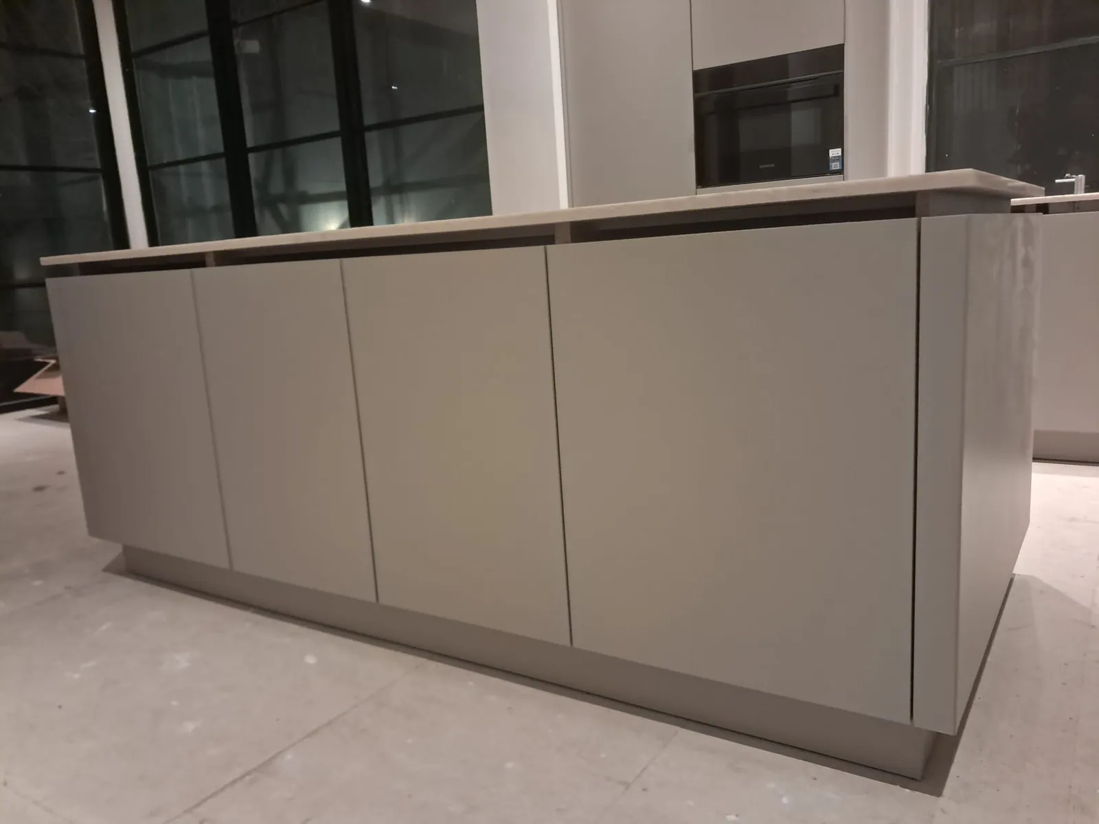 Zijaanzicht van het taupe kookeiland, keukenmontage in Bergen